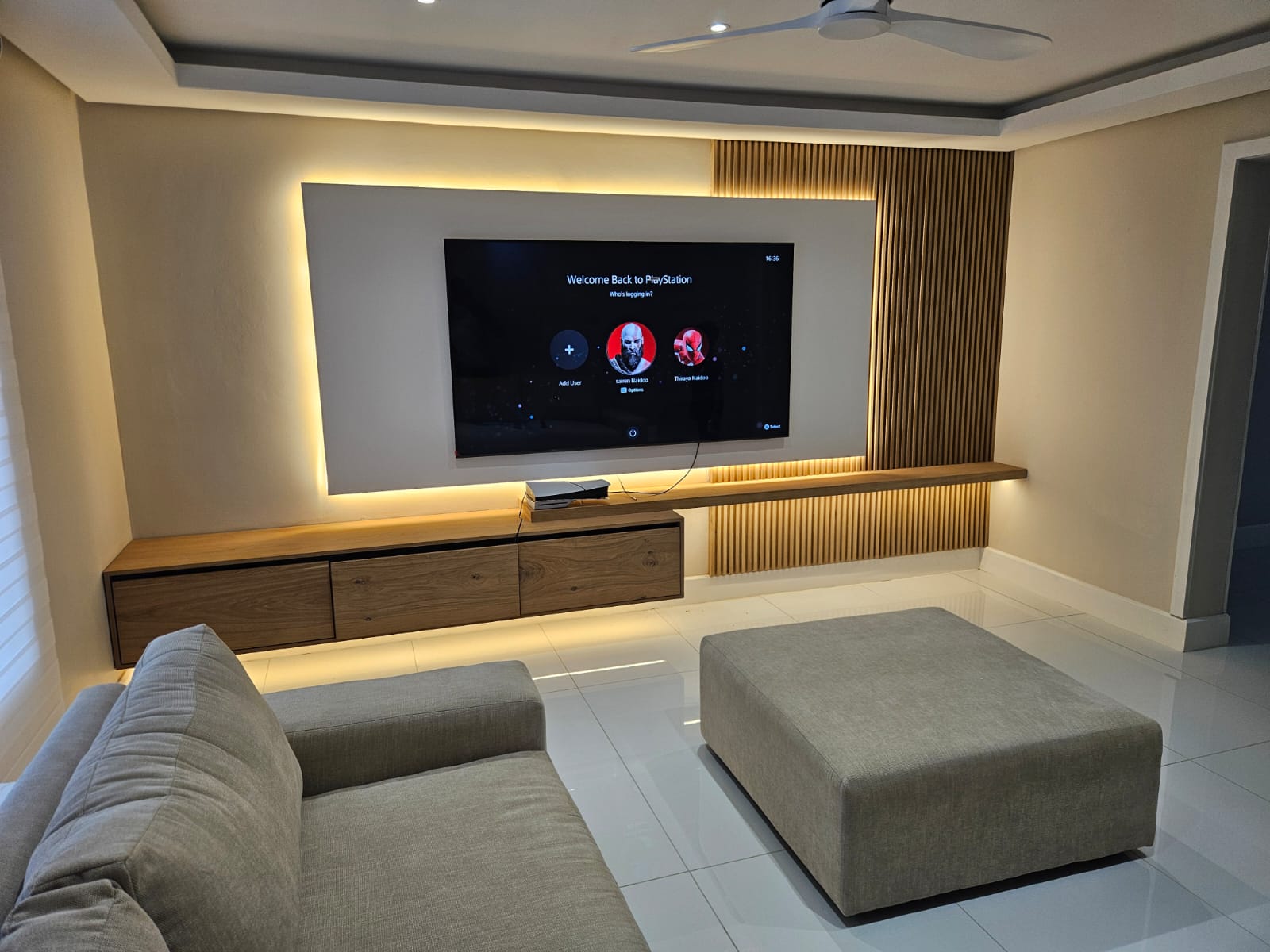 Backlit TV feature wall with LED cove lighting and floating media unit